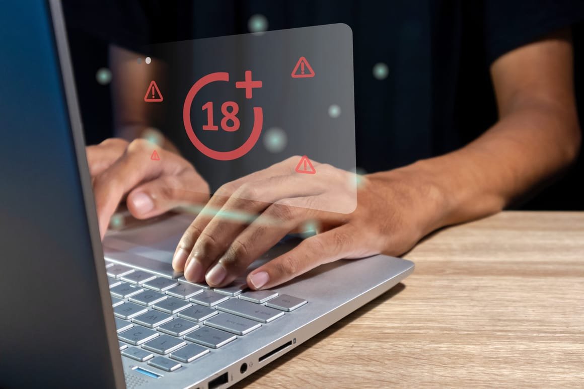 Man using laptop with restricted content icon for mature audience on virtual screen